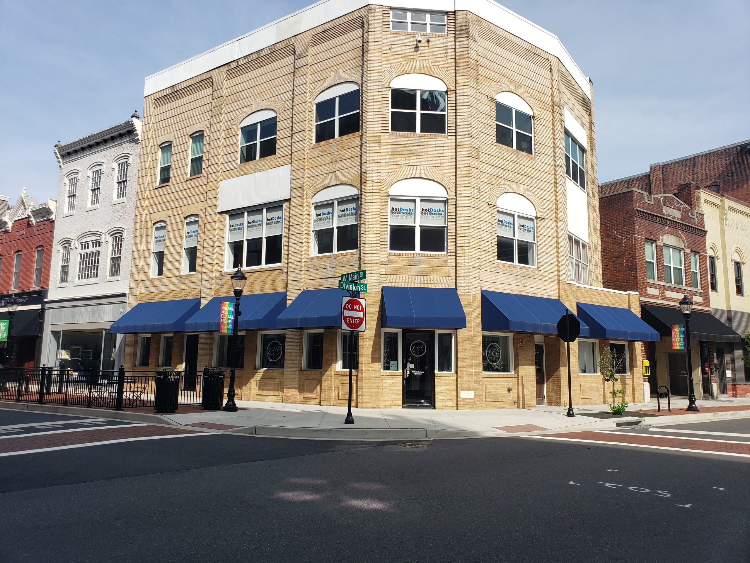 Downtown Salisbury corner building with blue awnings and hotDesksSBY coworking on W. Main St.